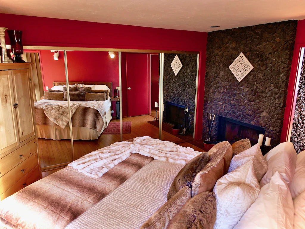 This main bedroom is very magnificent, with a lava rock fireplace and king-size bed, as well as a stunning wardrobe with wall-to-wall mirrors.