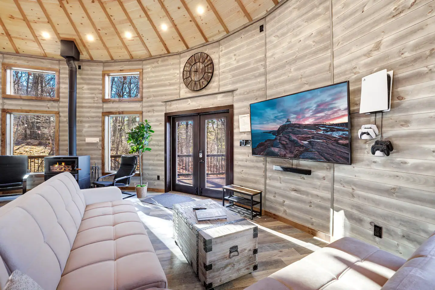 75" TV with Play Station 5, four controllers, and seating for eight people.