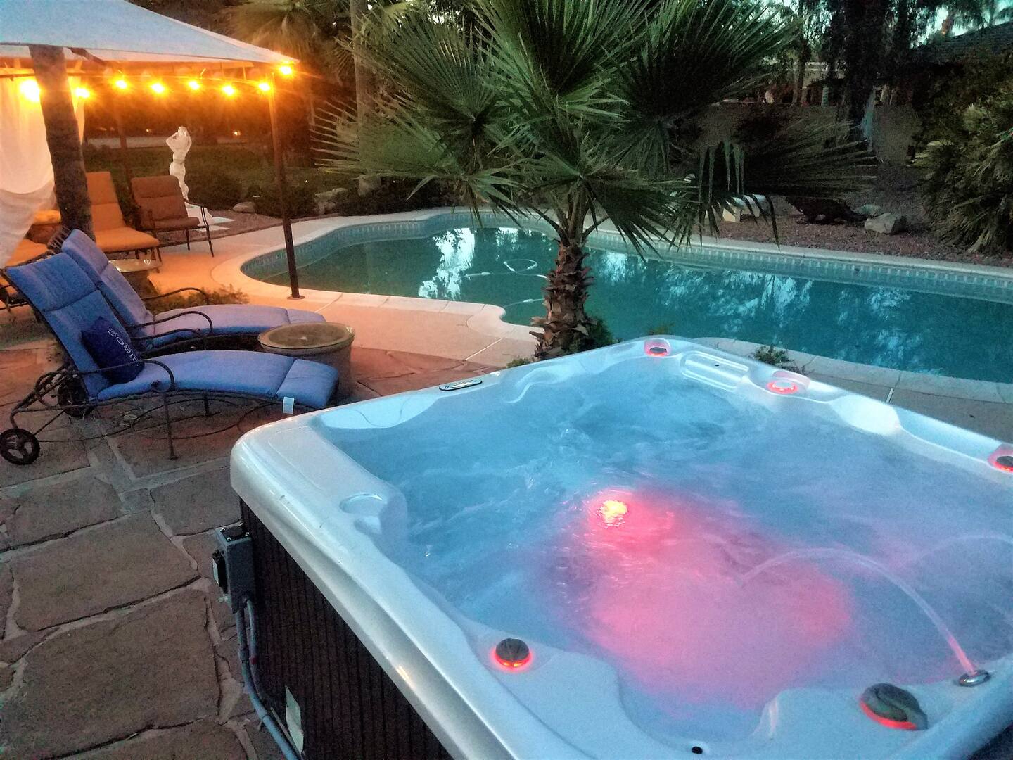 The extensive desert oasis on a one-acre plot is filled with lush greenery and offers privacy. It features a gas heated pool (additional charge for heating), a sizable hot tub (complimentary), and a sport court.