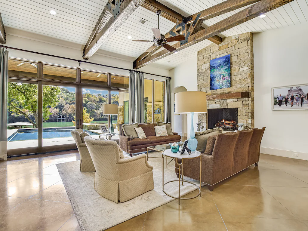 The high ceilings create a spacious and impressive atmosphere, and the comfortable leather furniture and stone fireplace provide a cozy and homey feeling.