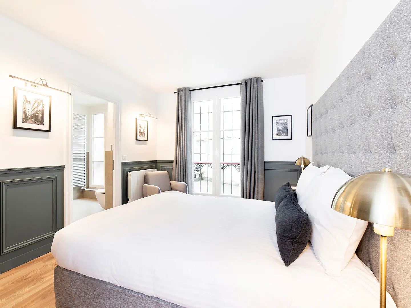 Second bedroom with double bed, linen, working space, ensuite bathroom and view over a calm courtyard