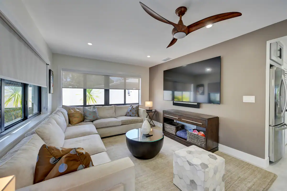 Relax in the living room adorned with a luxurious sofa and a grand 90-inch TV.
